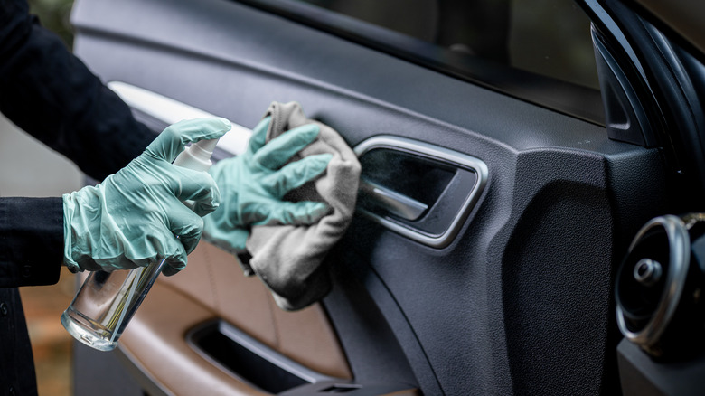 Person cleaning inside car door 