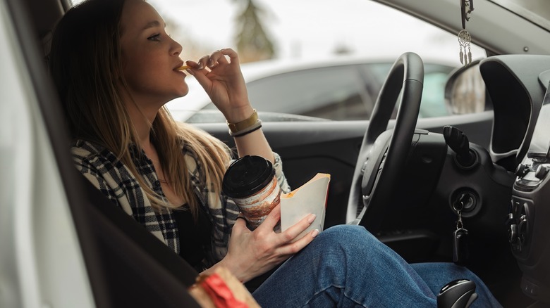 woman in the car eating and drinking 