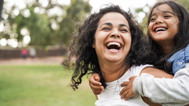 a mom and daughter smiling together 