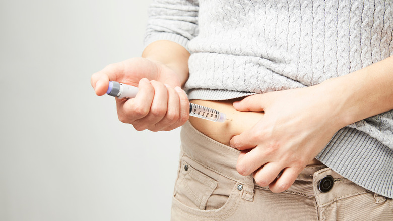 woman giving herself insulin