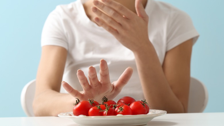 woman refusing food on plate