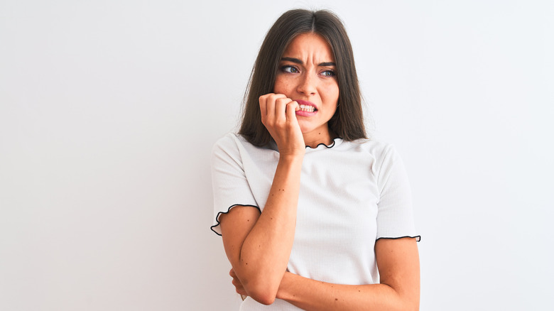 A woman bites her nails nervously