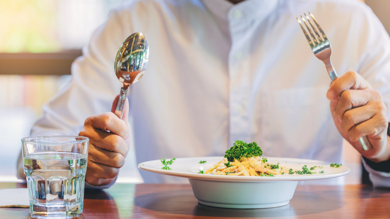 A man gets ready to eat pasta