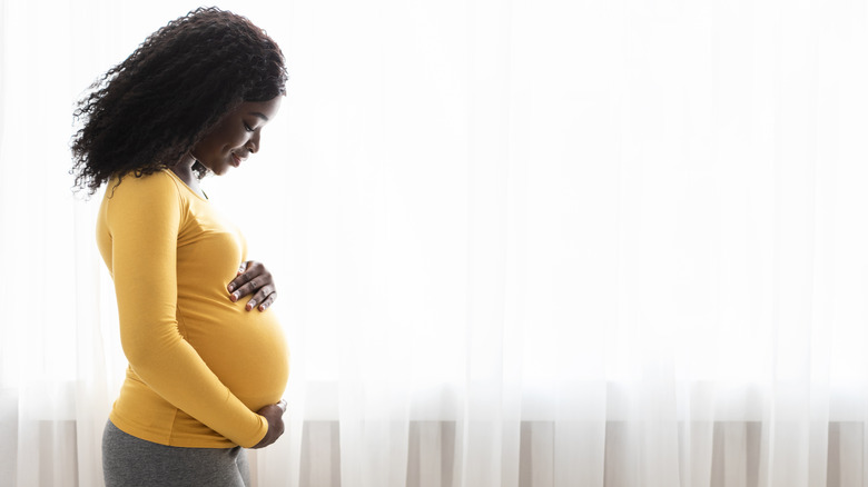 Pregnant woman holding belly