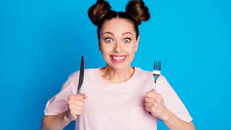 woman holding fork and knife
