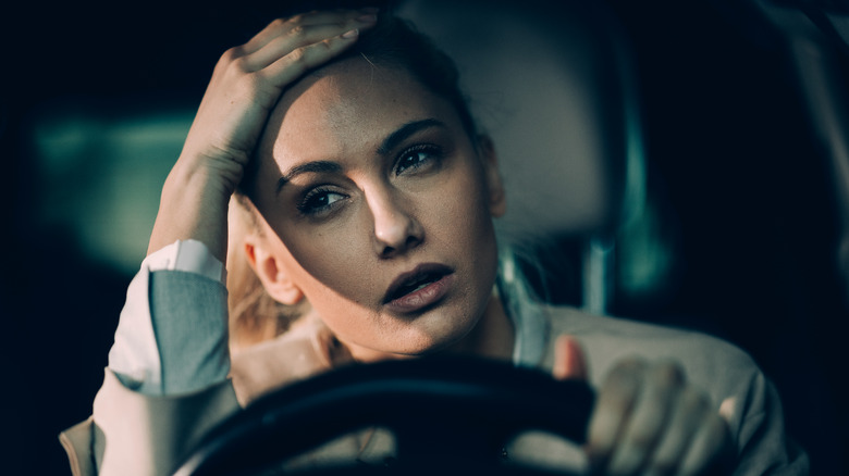 Tired woman driving car at night 