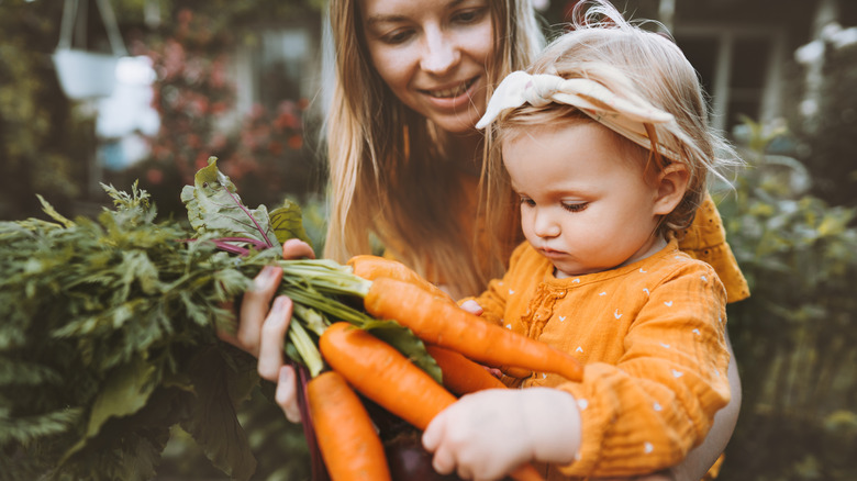 Adult and child holding carrots