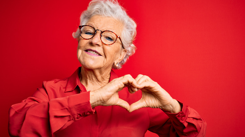 senior woman with heart-shaped gesture