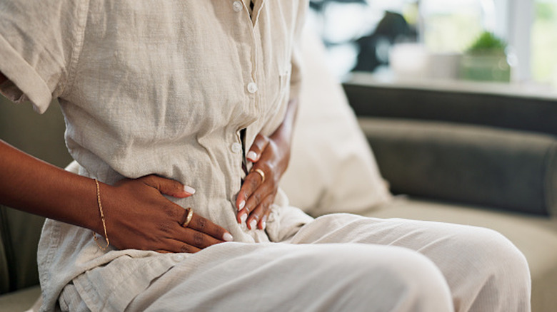 Woman holding stomach in pain