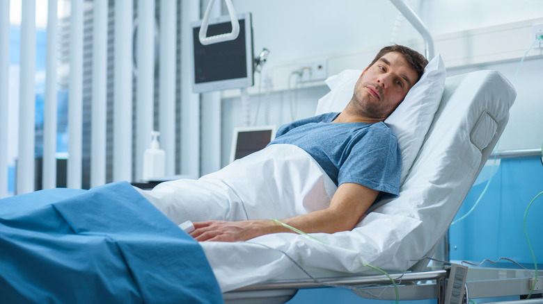 Man lying in hospital bed recovering from surgery