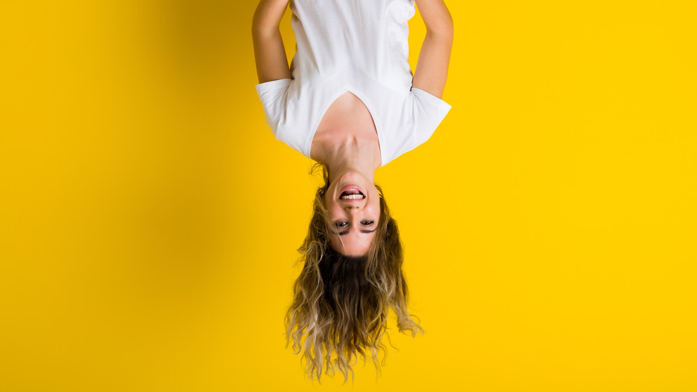 woman hanging upside down wearing white shirt