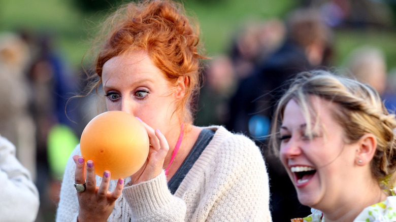 woman blowing up a balloon