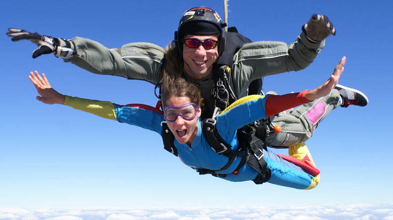 Woman skydiving strapped to male instructor 