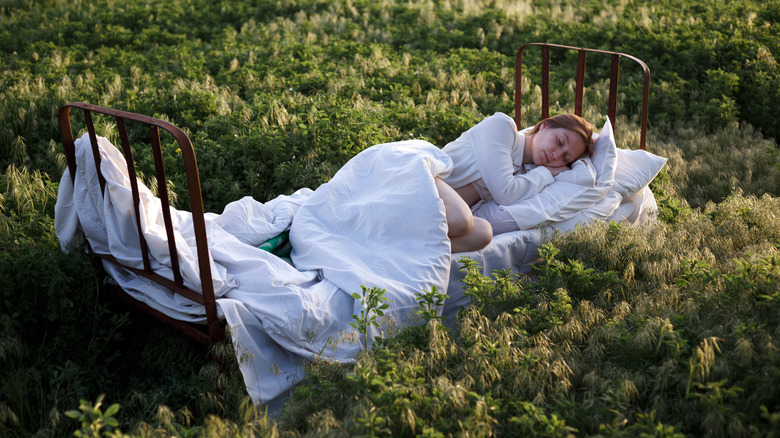 woman sleeping on bed in forest