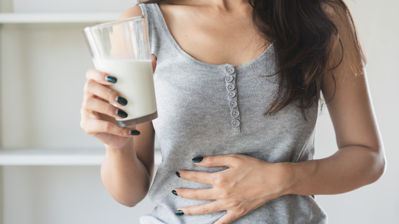 lactose-intolerant woman holding glass of milk
