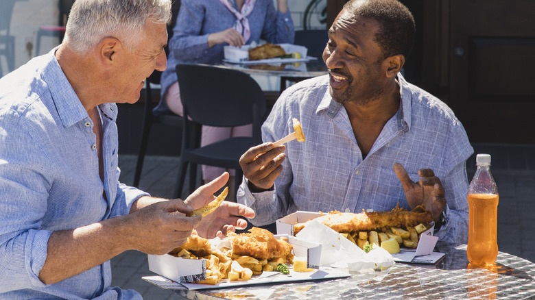 Two friends eating fried foods