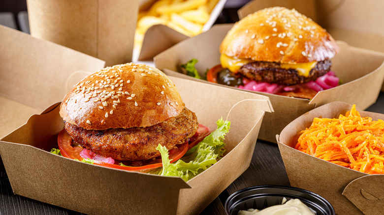 to-go boxes filled with burgers and fries