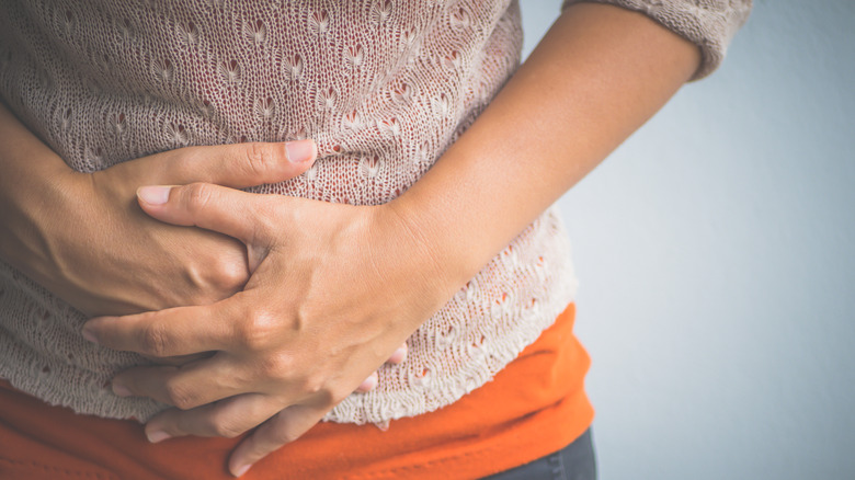 Woman's hand holding stomach 