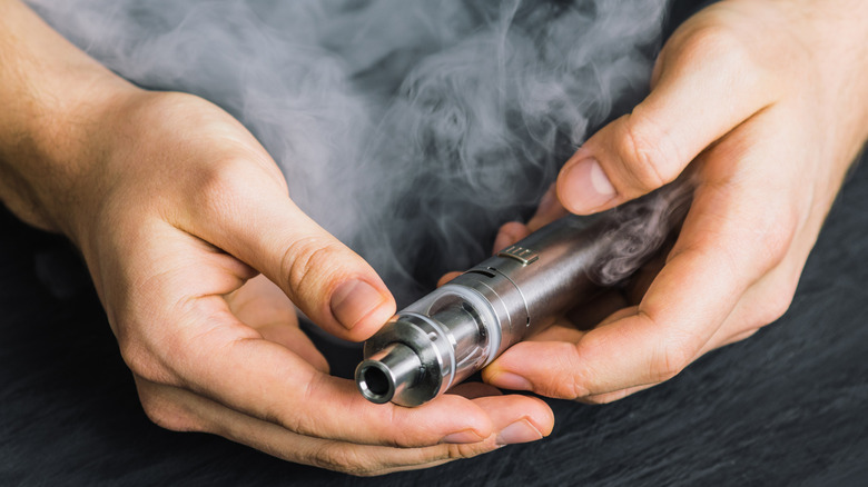 Hands holding a vape