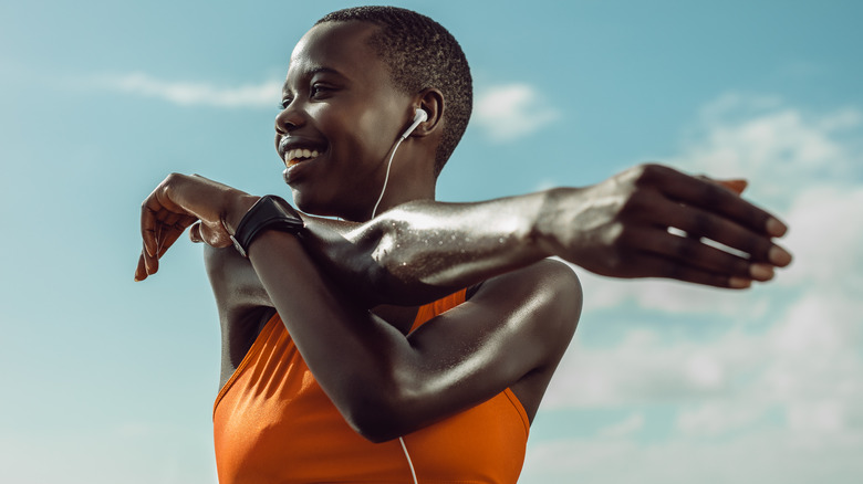 Woman stretching arms outside