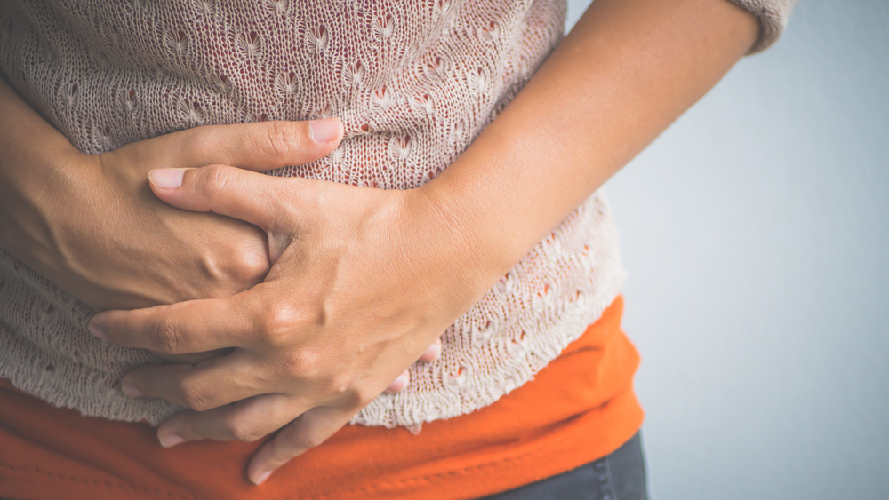 Close up of a woman's hands pressing on her stomach