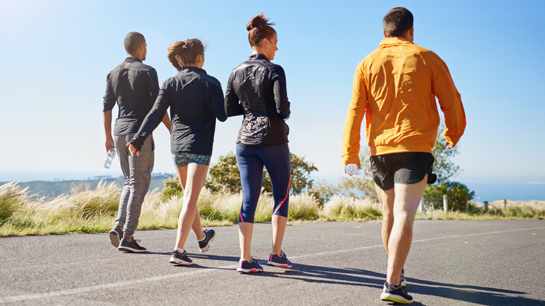 Four people in fitness clothes walking away from the camera