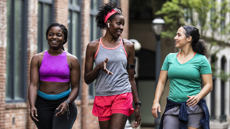Three women fitness walking while talking