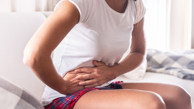 Seated woman with pain in abdomen