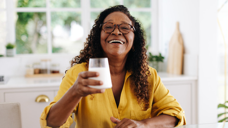 smiling older woman drinking milk