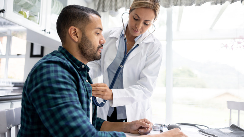 Doctor examining patient with stethoscope