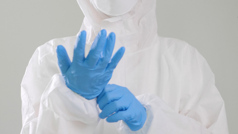 healthcare worker wearing blue latex gloves