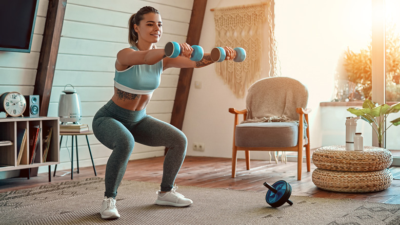 A woman lifts weights at home