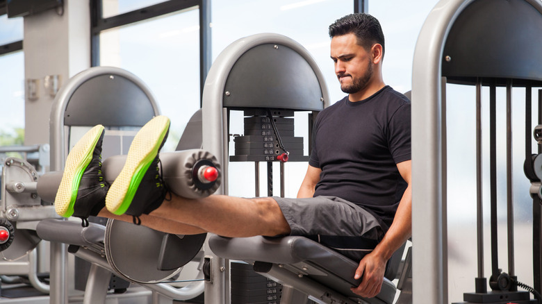 A man uses a leg extension machine