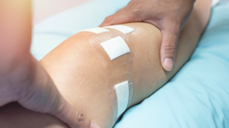 Person touching bandaged leg