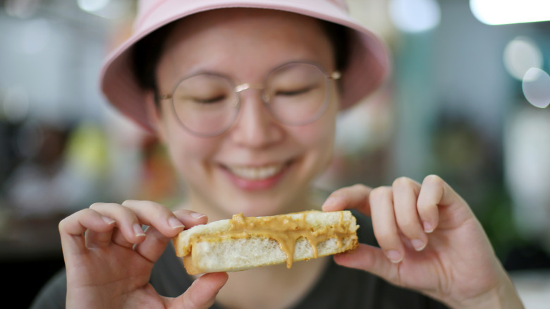 Woman eating peanut butter sandwich 