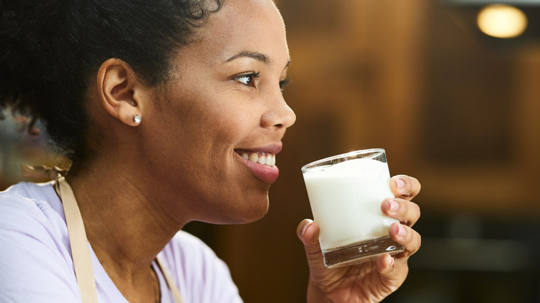 woman drinking small glass of milk