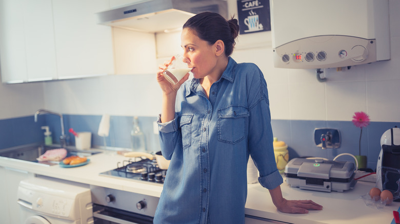 Woman drinking milk in a kitchen