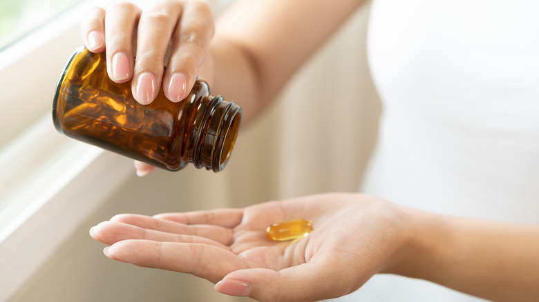 person with a supplement in their hand