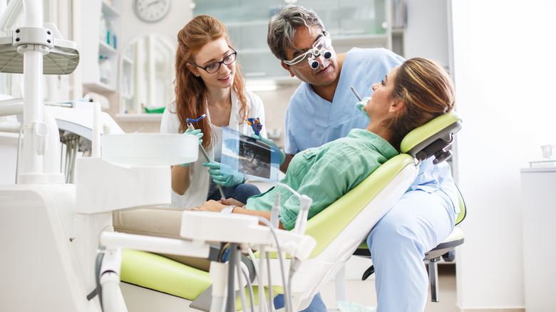 woman with dentist and assistant