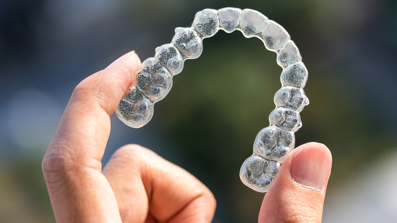 close-up of hand holding a retainer