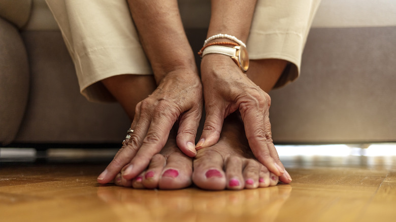 Woman's hands touching her feet