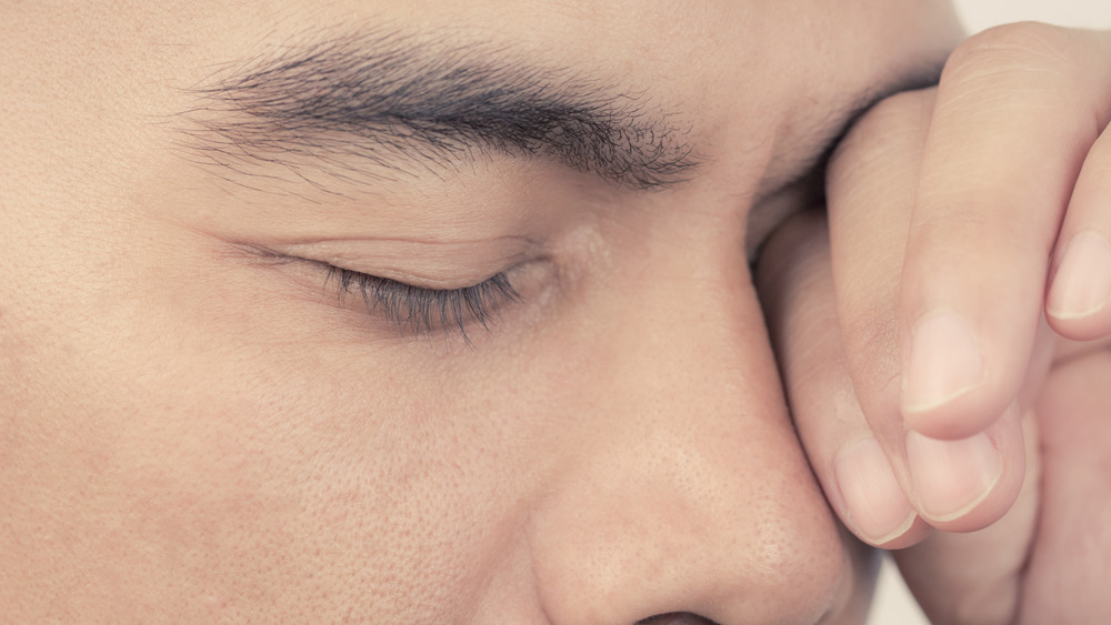 Man rubbing eyes