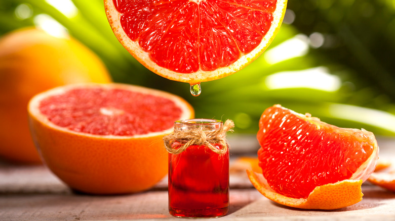 Grapefruit halves dripping into essential oil