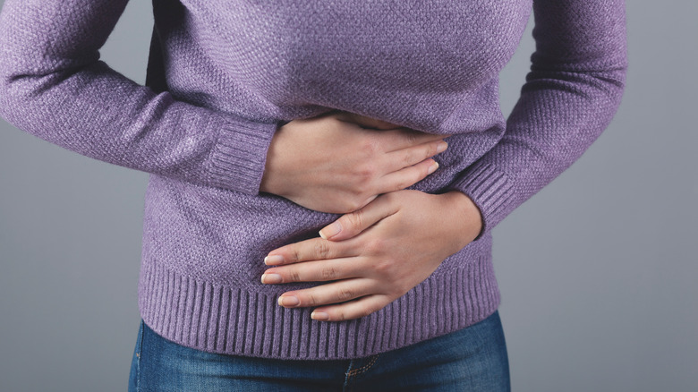 Close up of woman clutching stomach in pain