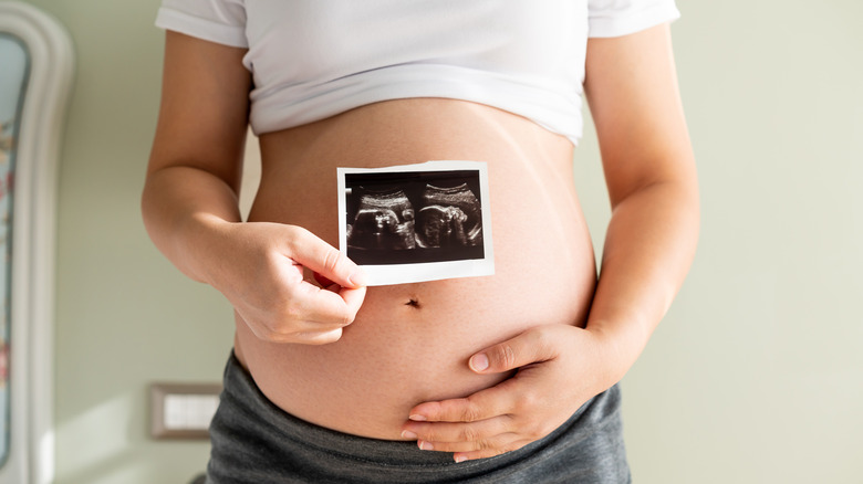 pregnant woman holding ultrasound image