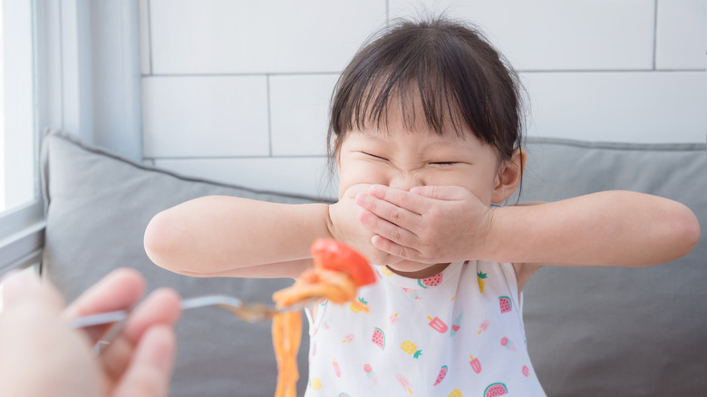 child refusing spoon feeding