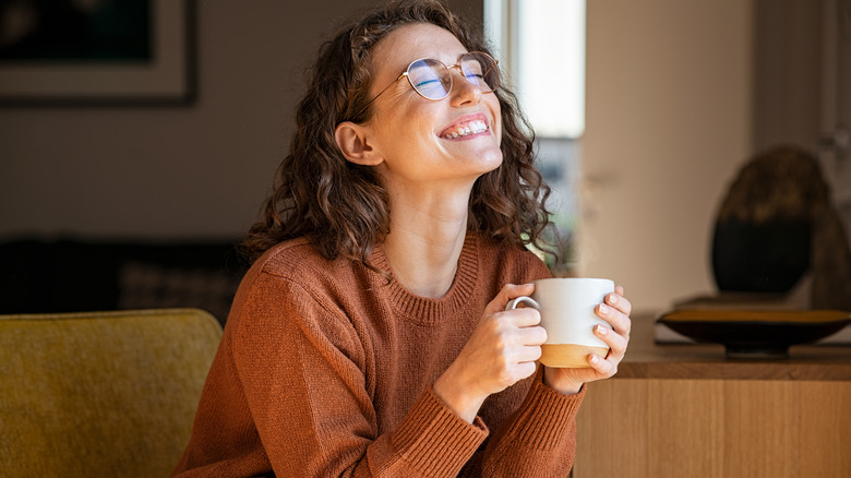 woman laughing with cup in hand