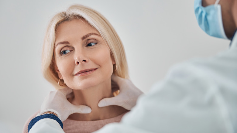 women getting her thyroid examined