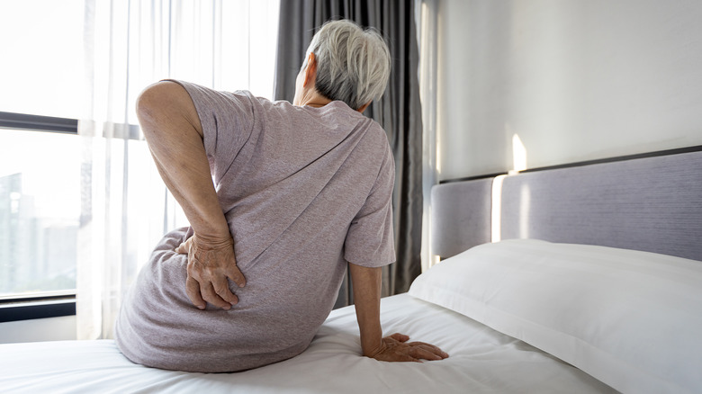 man with pain sitting on bed