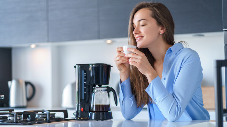 Woman drinking a cup of coffee in the kitchen